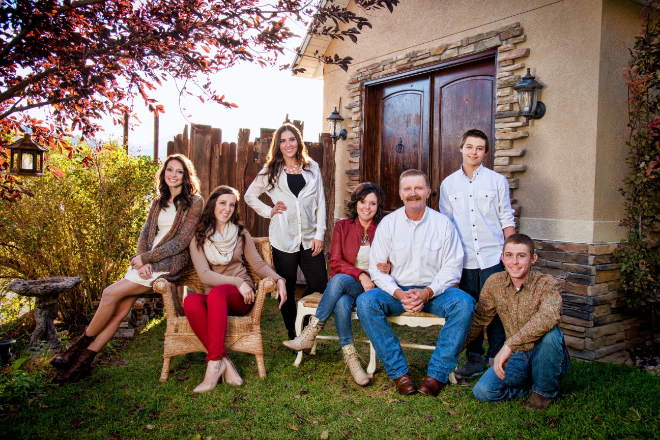 A family posing in front of a building with a large wooden door.