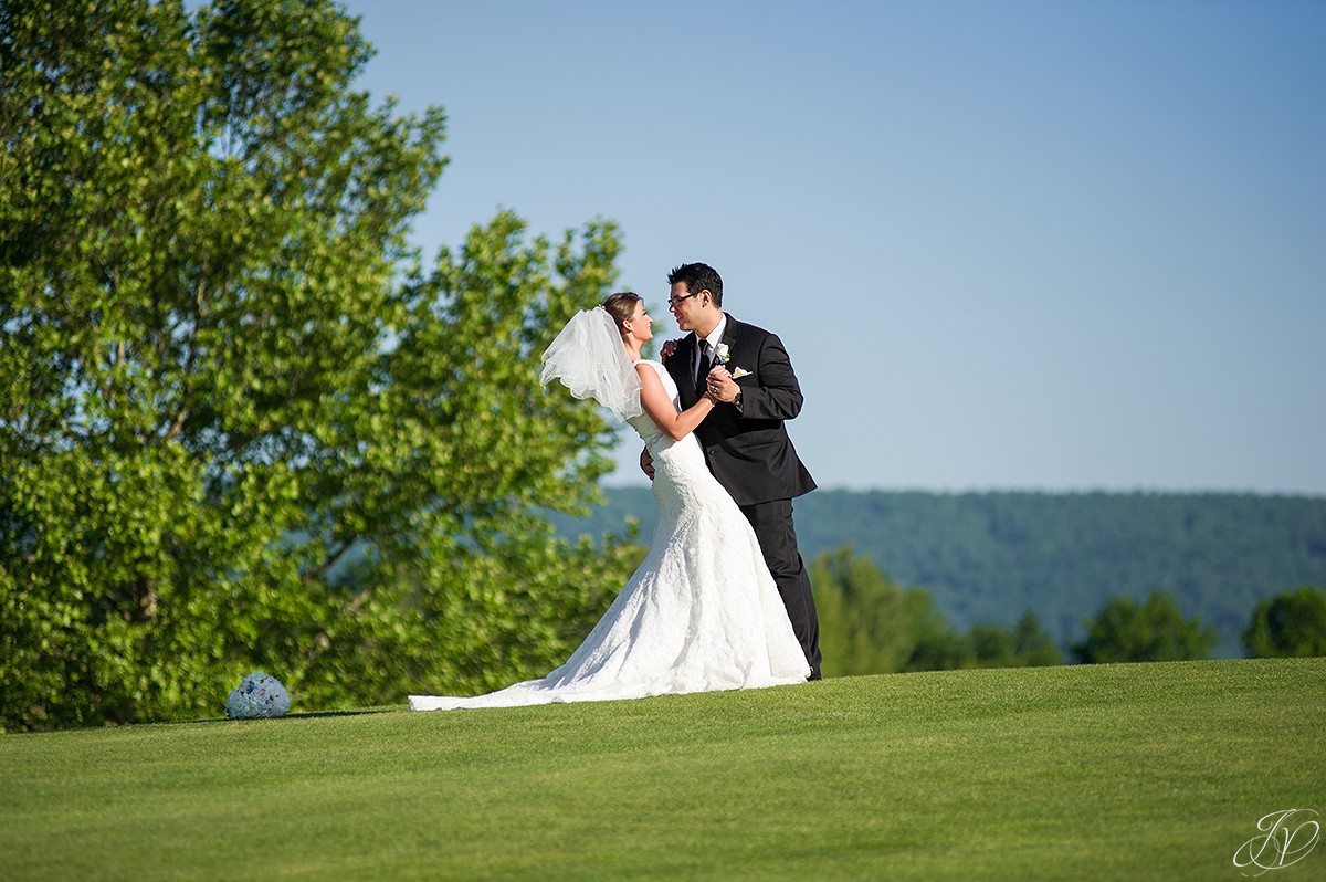 groom dipping bride outside on golf course