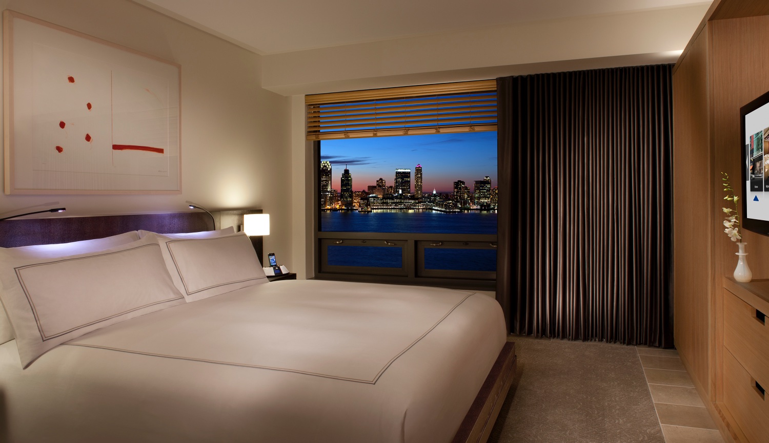 A Modern Conrad Hotel Guest Room in New York City overlook Jersey City Skyline.