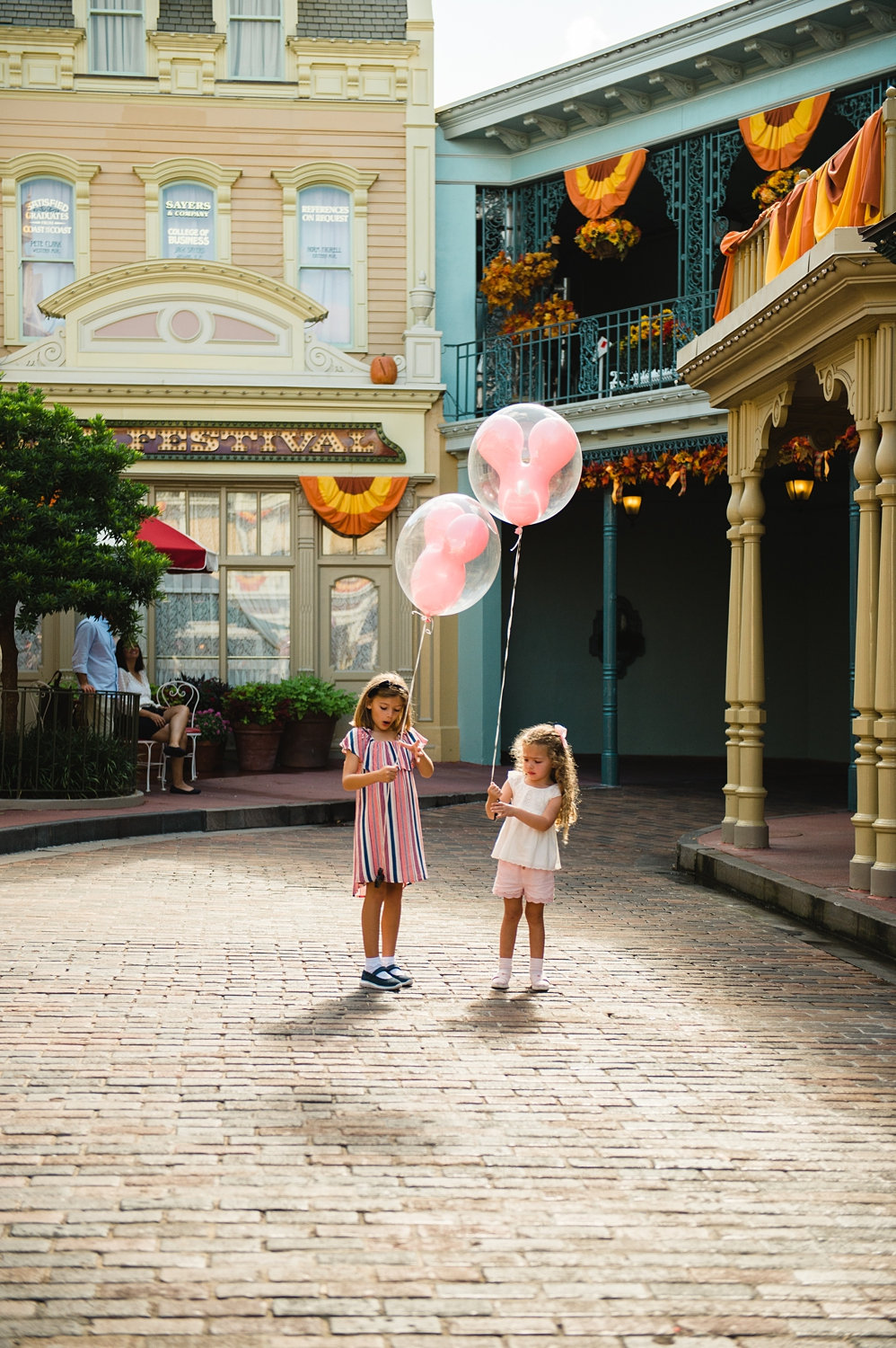 two girls with Mickey balloons, Main Street U.S.A. fall decorations, Ryaphotos