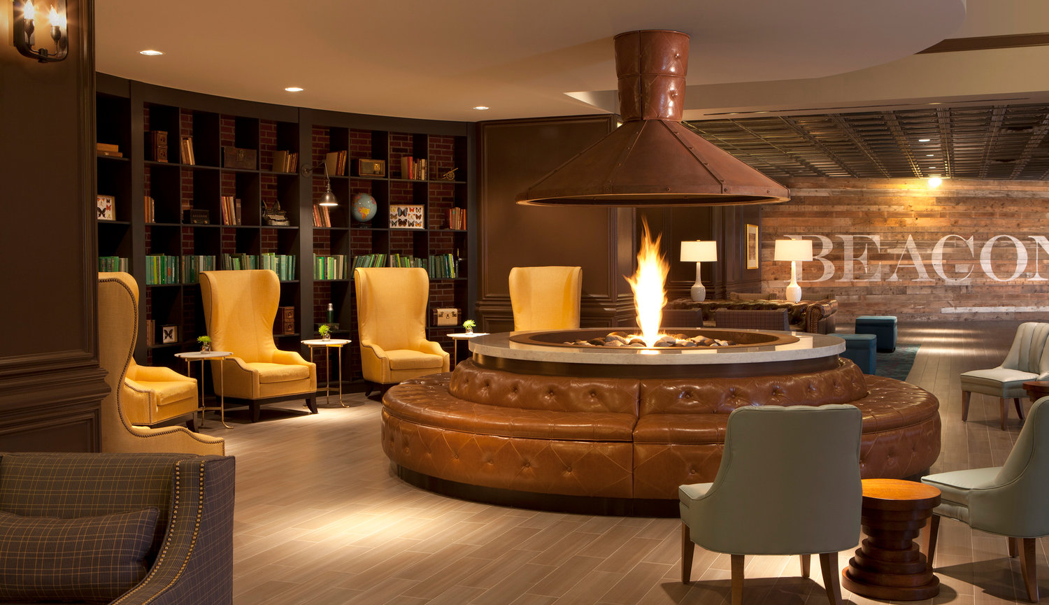 Really nicely decorated Hotel Lobby in Minnesota with a circular fireplace for many to sit with a library style background.