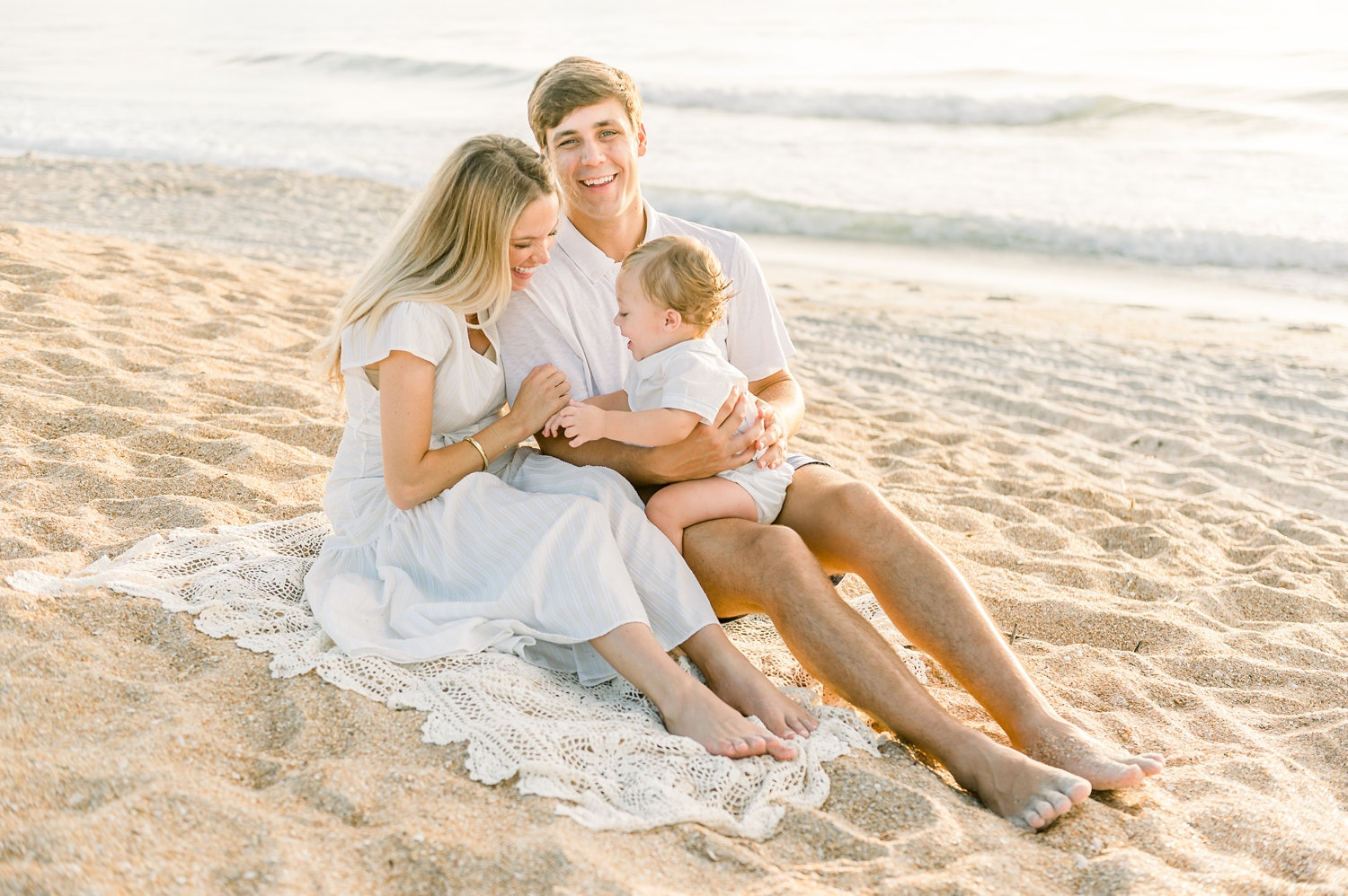 mom, dad, and baby boy sitting in the Florida beach sand, Rya Duncklee