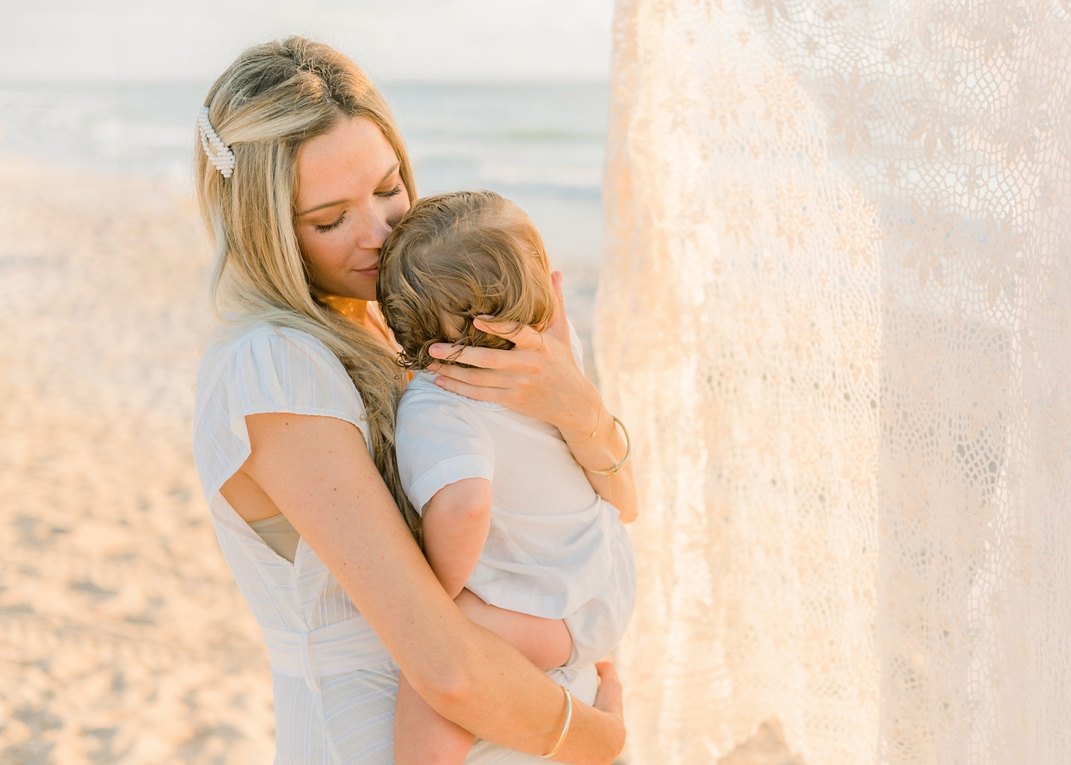 mother nuzzling her baby boy, eyelet curtain, coastal family portraiture