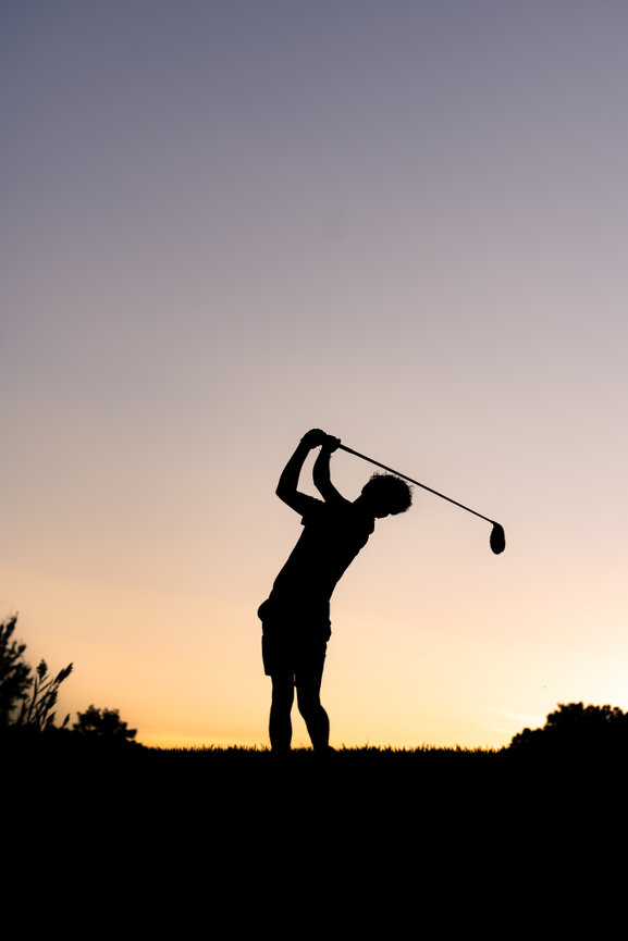 Silhouette of a senior boy golfer swinging a club at sunset in clarkston mi