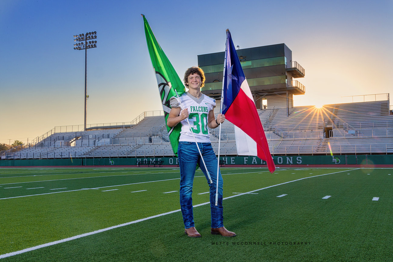 High school senior football player guy on field sunset with texas flag