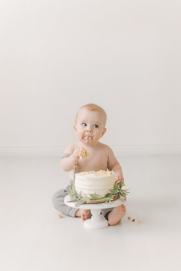 Baby eating cake in a Minneapolis studio setting