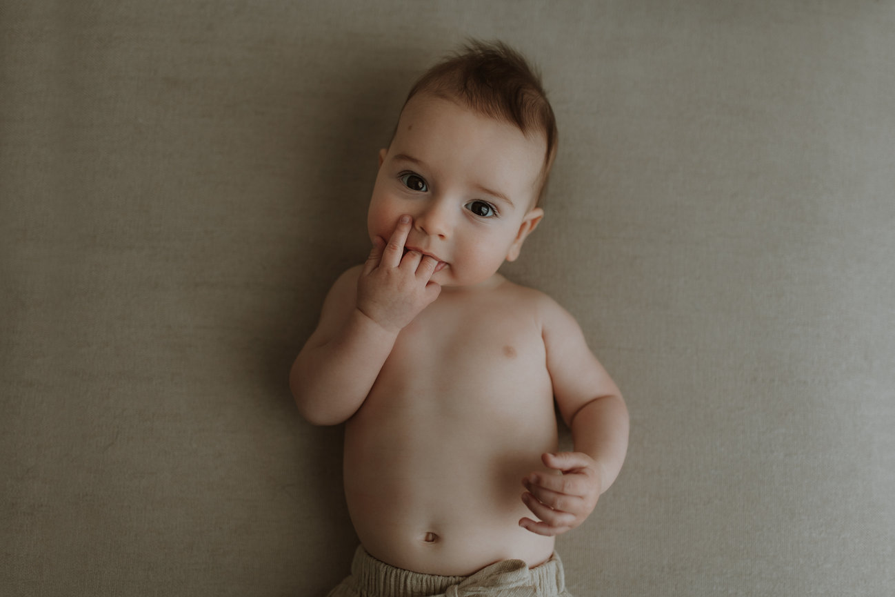 A portrait of a baby sucking his fingers at a New Jersey lifestyle baby photography session.