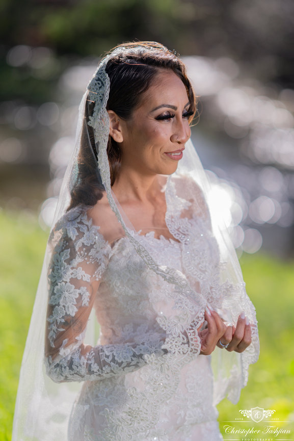 Bride smiling with lace veil outdoors