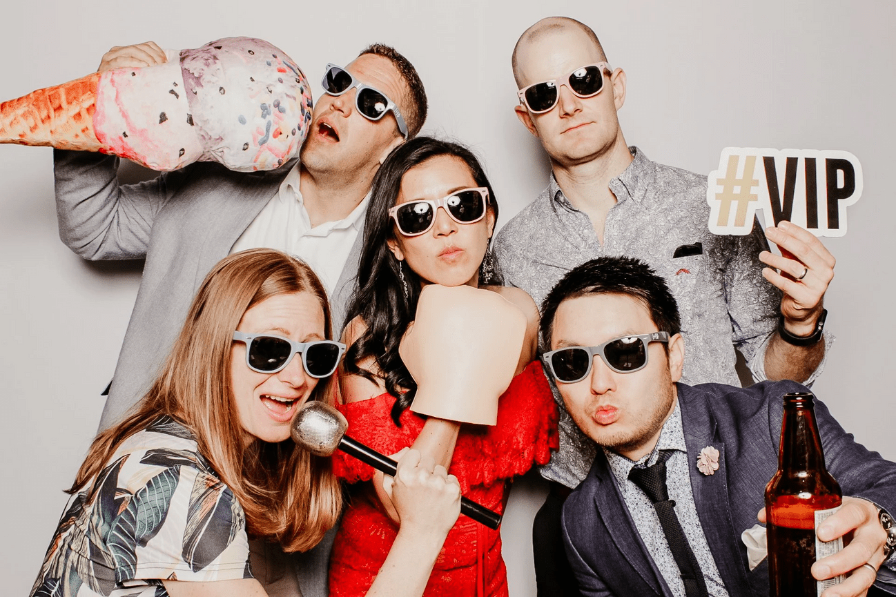 Group posing with oversized props and wearing shades