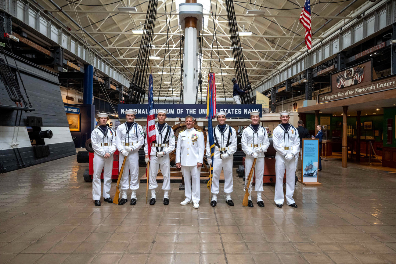 Naval Officer posing with a ceremonial guard during his retirement ceremony