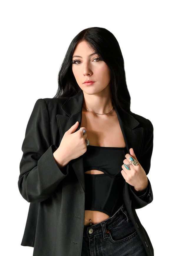 model in a black blazer and denim sitting confidently against a minimalist white background, showcasing high-fashion style. Captured by Tre Nelson Photo, featured in Vessel Magazine.