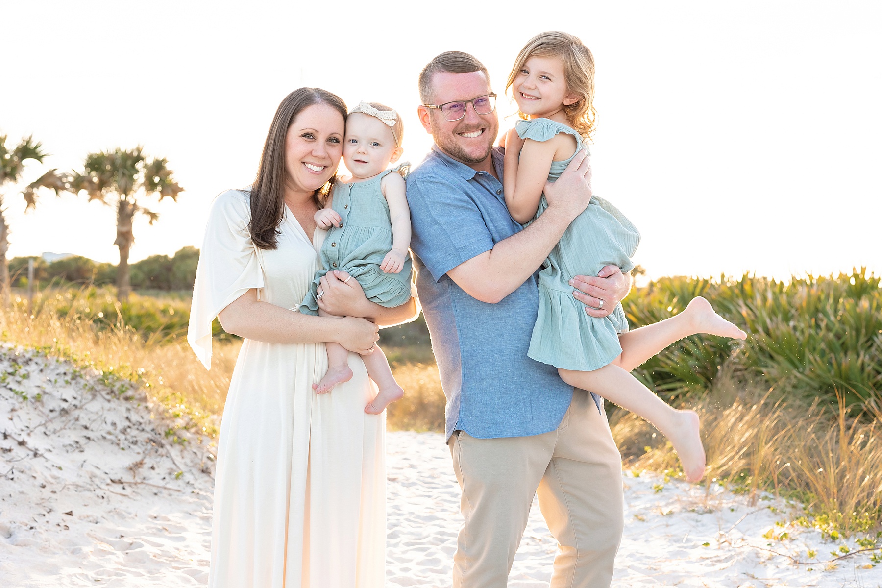 family smiling at the camera on the beach in Florida