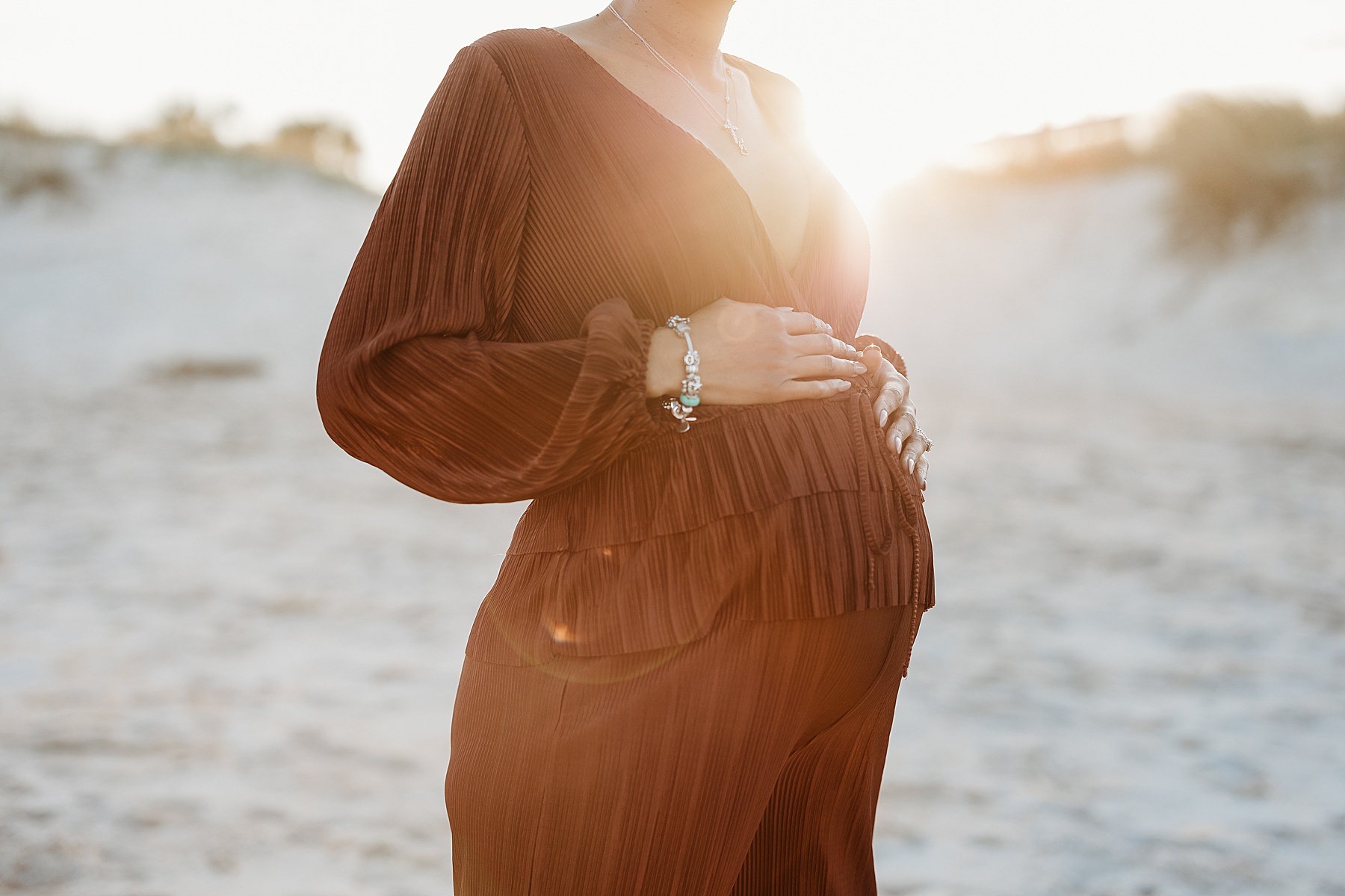 backlit photo of pregnant woman on the beach at sunset