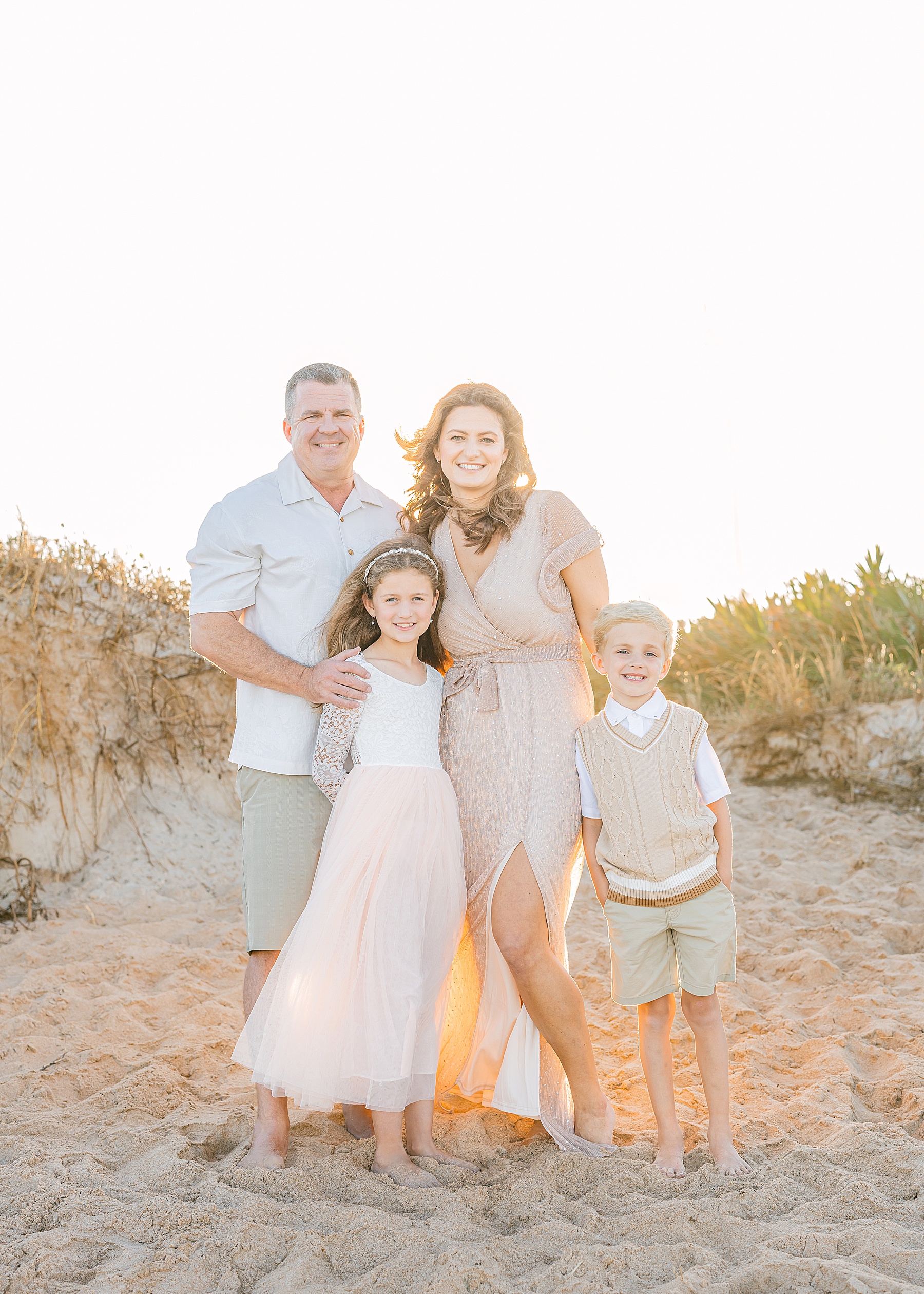 family wearing neutral colors for a sunset beach portrait in Saint Augustine Beach Florida 