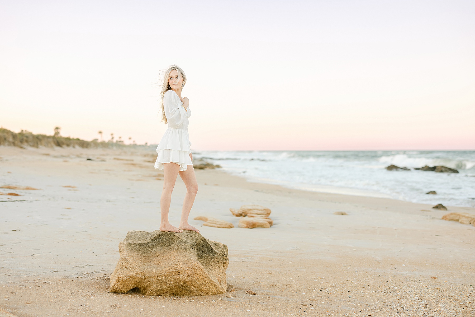graduate photograph at sunset with pastel skies on the beach at Marineland Florida