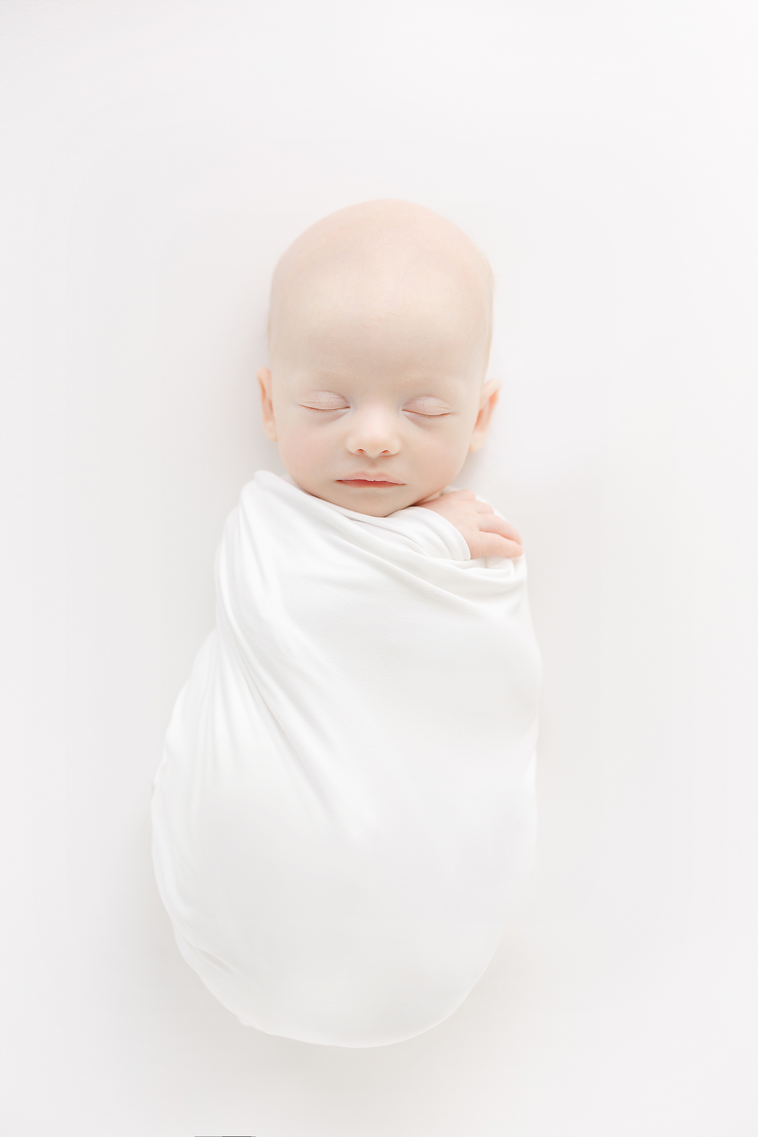Light and airy all white newborn portrait of a baby boy.