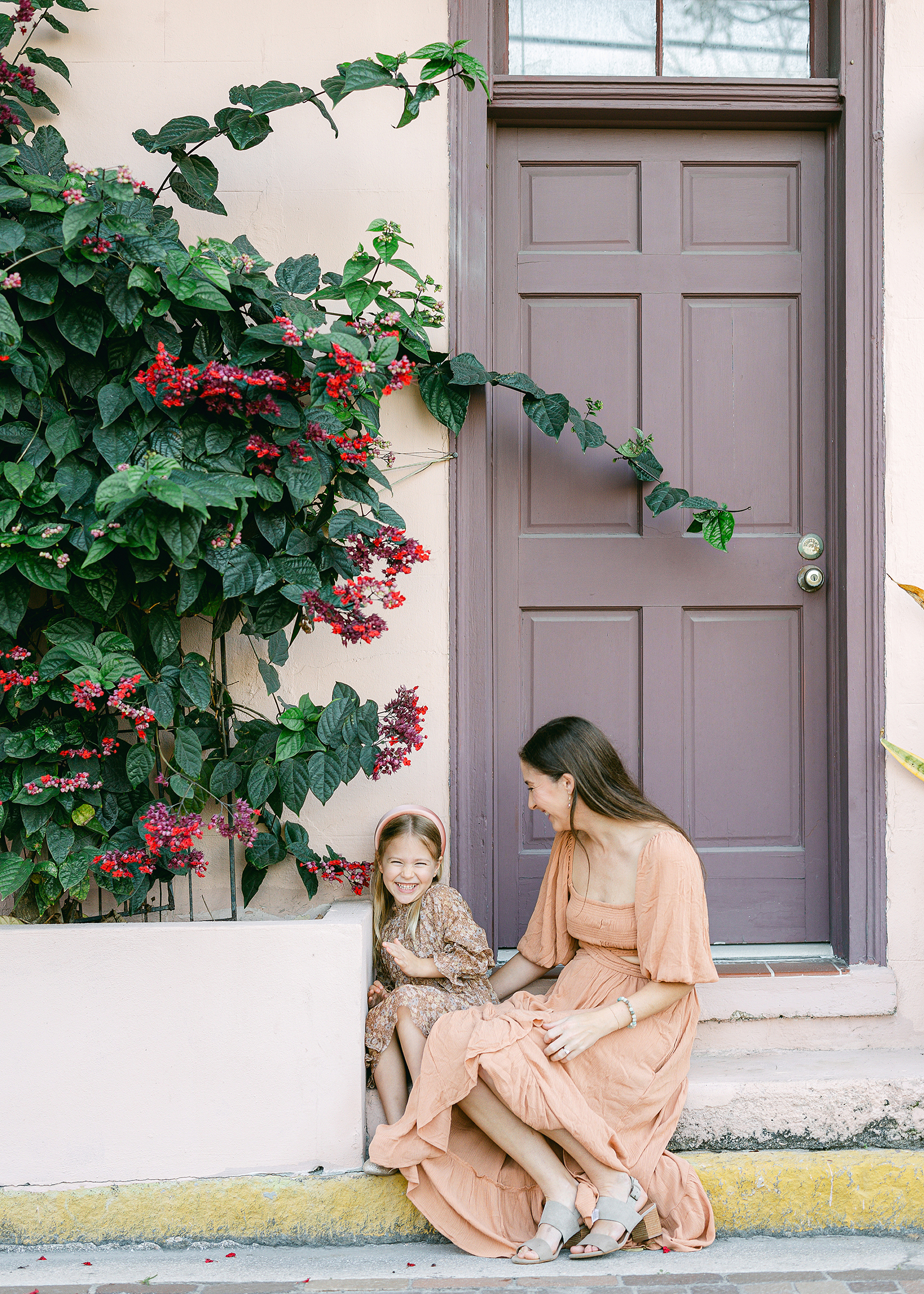 Mother and daughter in neutral colors in front of purple door in historic downtown Saint Augustine, Florida.