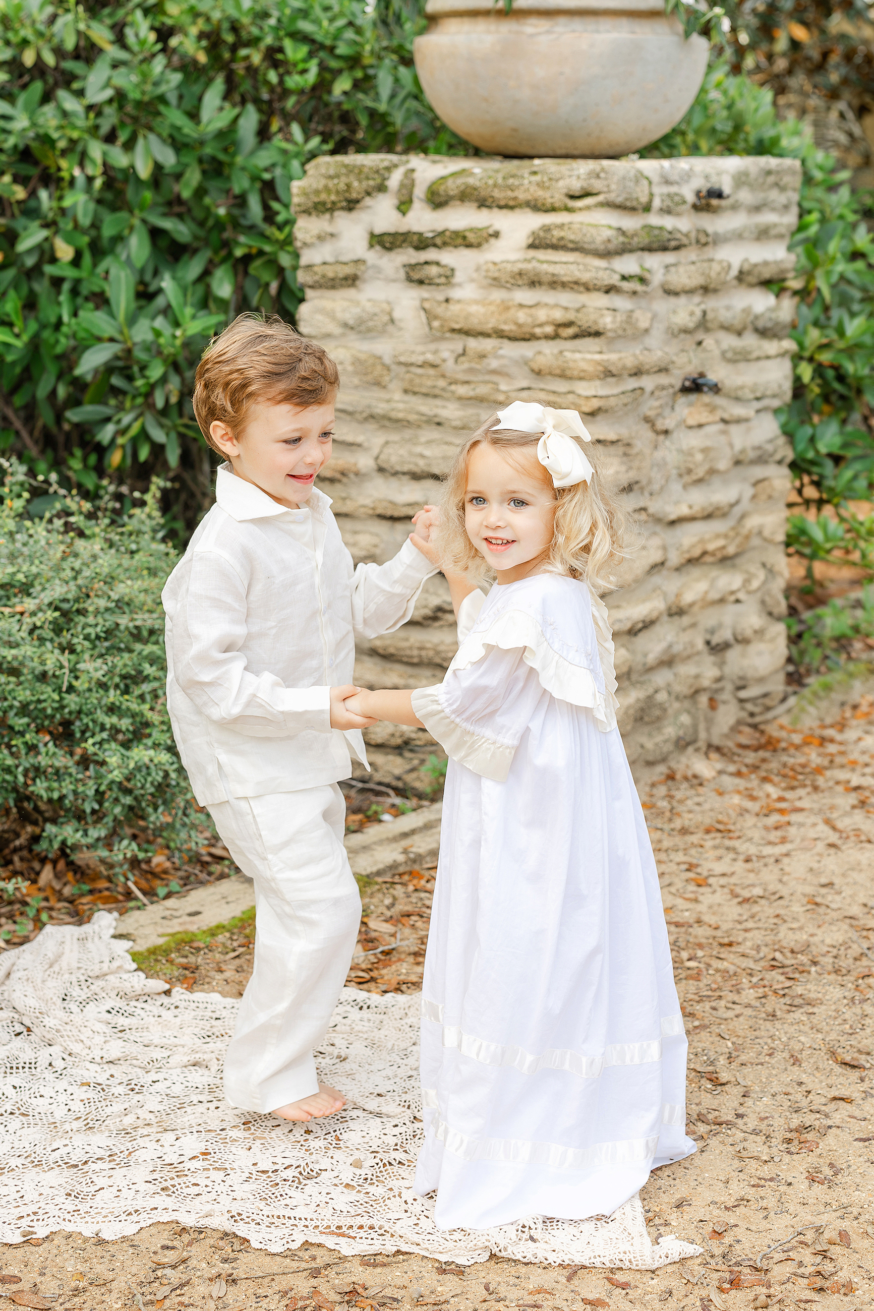 A spring portrait of two children dressed in white dancing together at Washington Oaks Gardens State Park.