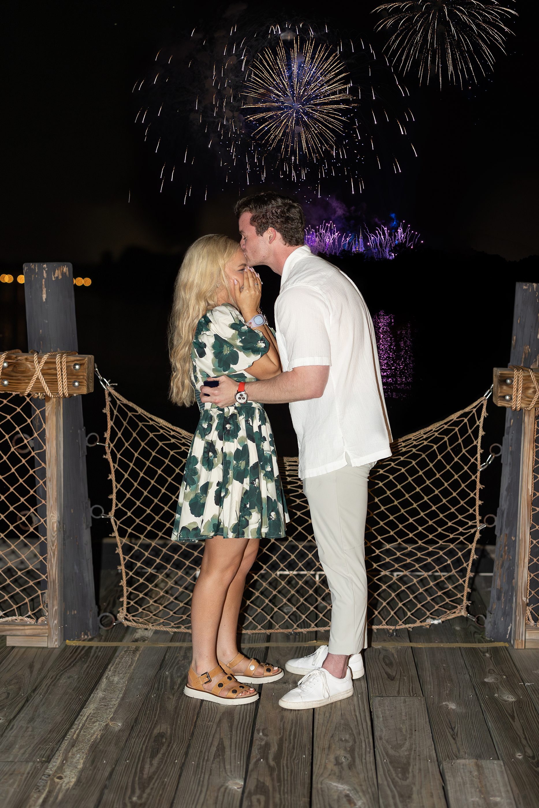 Surprise proposal during Happily Ever After fireworks show at night at Disney.