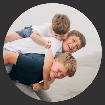 three boys at beach laughing