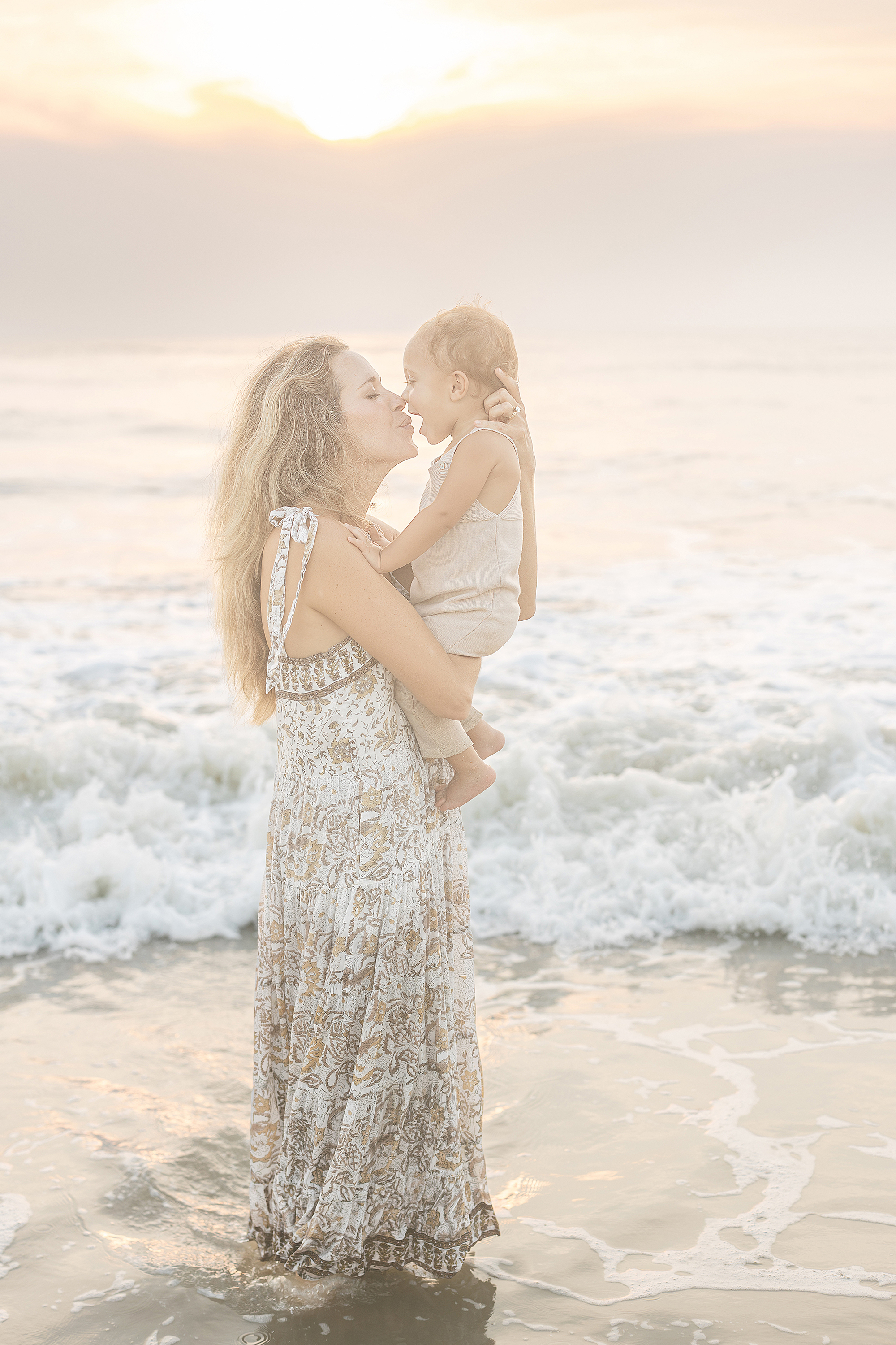 A hazy sunrise beach portrait of a mother and her one year old baby boy in Jacksonville, Florida.