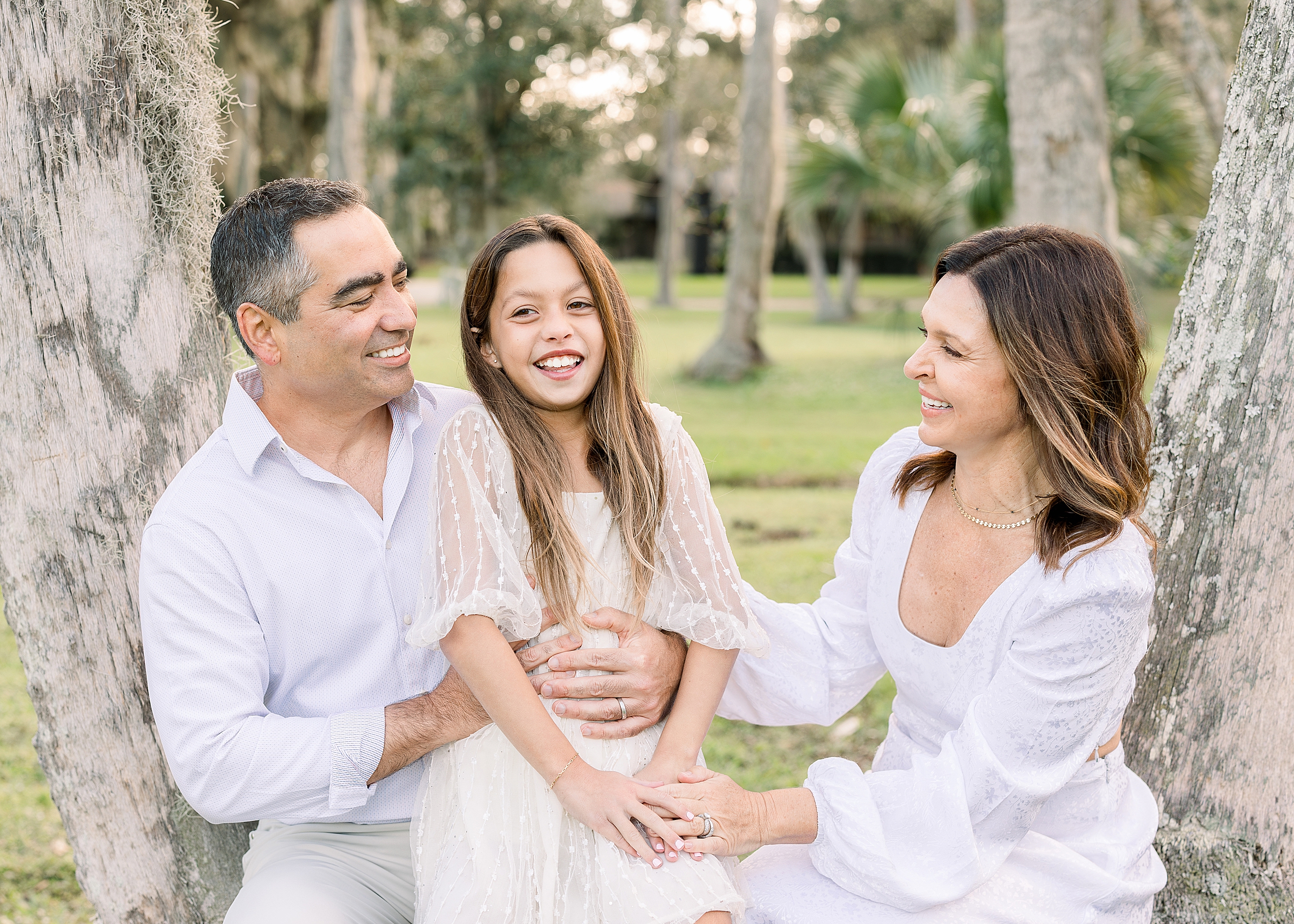 A family of three laugh together in Johansen Park in Atlantic Beach.