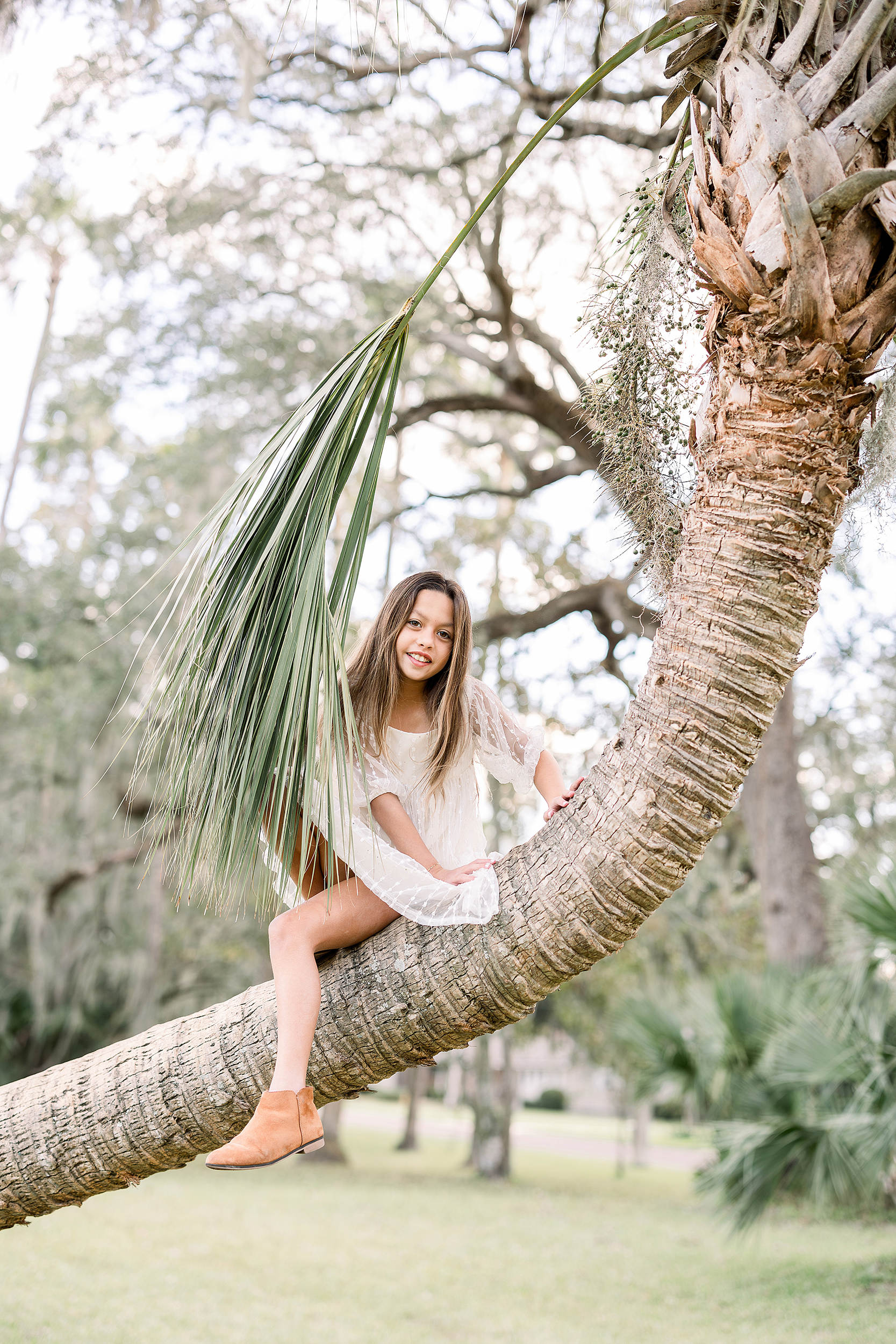 A little girl sits on a tree in Johansen Park in Atlantic Beach, Florida.