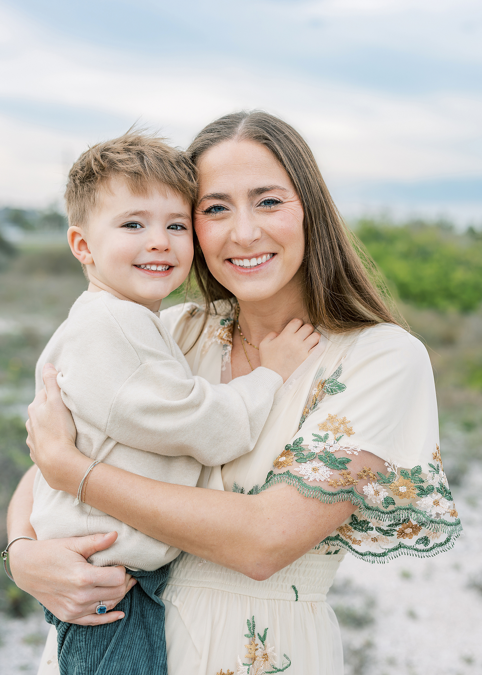 A woman and a little boy hug and look at the camera during a sunset family portrait session in St. Augustine.