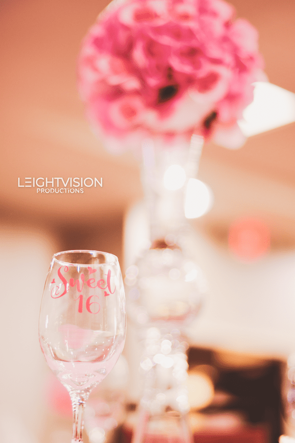A beautifully decorated wine glass featuring vibrant pink flowers, symbolizing a fusion of sophistication and floral charm.