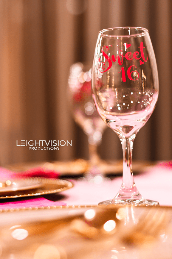 A wine glass featuring a decorative design celebrating a sweet 16 birthday milestone.