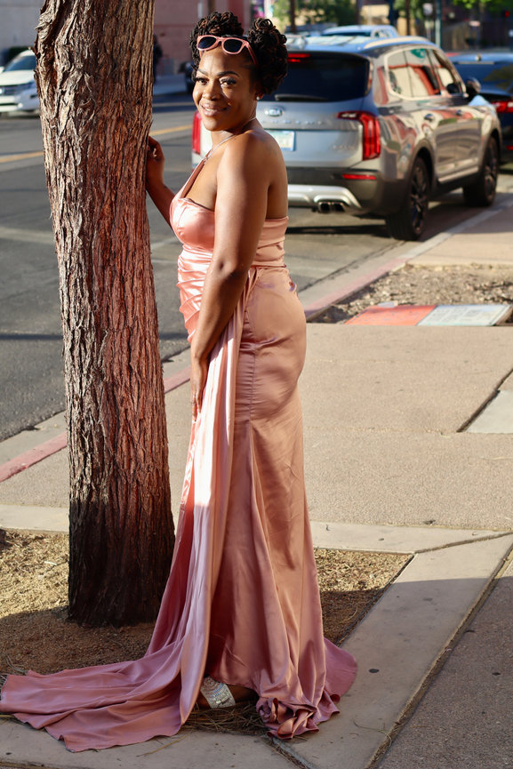 Woman in pink gown by a tree