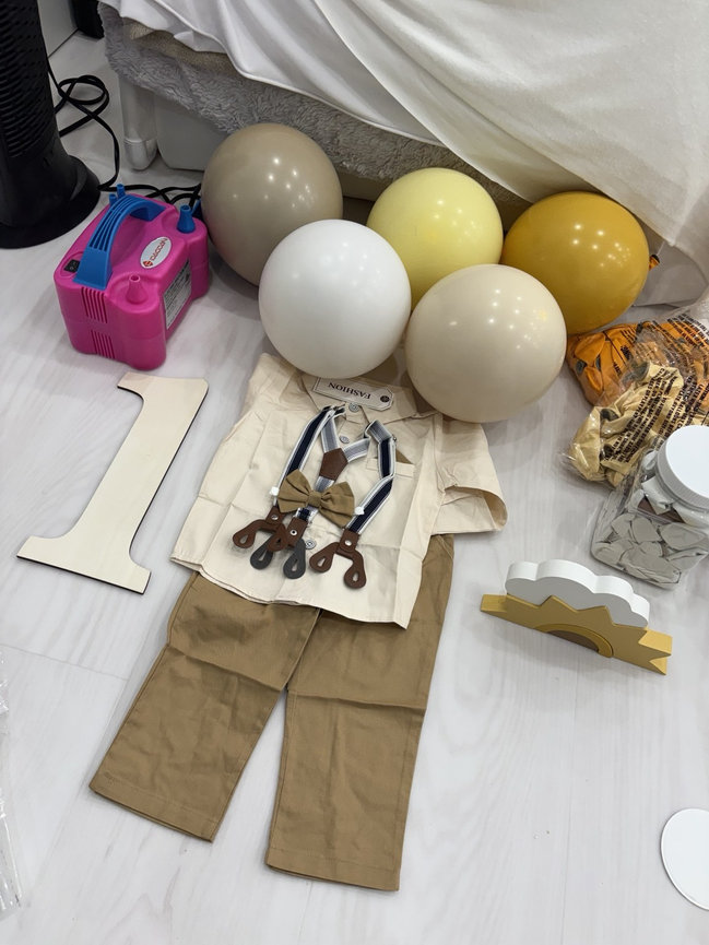 Neutral first birthday outfit and coordinating yellow, cream, and taupe balloons