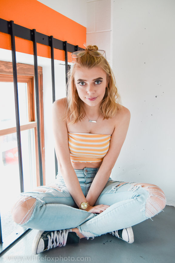 Fun senior year photo of girl in ripped jeans downtown Boise, Idaho