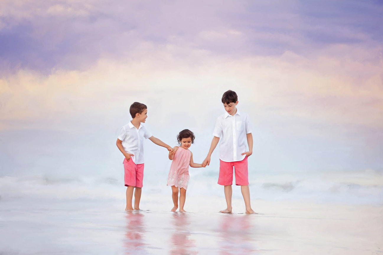 Children playing along the shoreline, captured in an organic and emotive beach session near Raleigh.