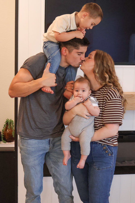 Parents holding their children including a newborn baby in a family portrait