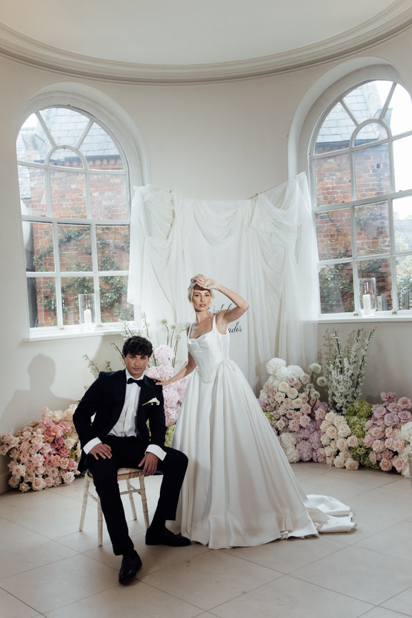 Modern bridal portrait with pastel floral arrangements; a bride playfully shielding her eyes from an editorial flash at Iscoyd Park.