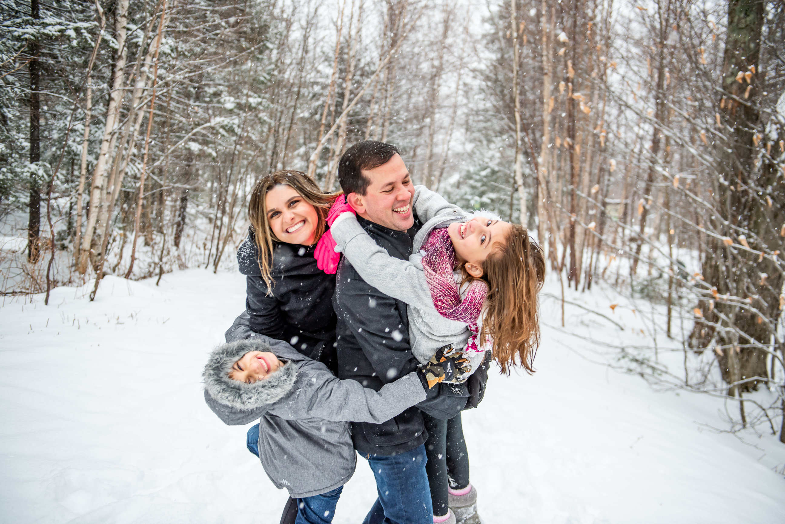Family laughing in the snow during a winter session in Stowe