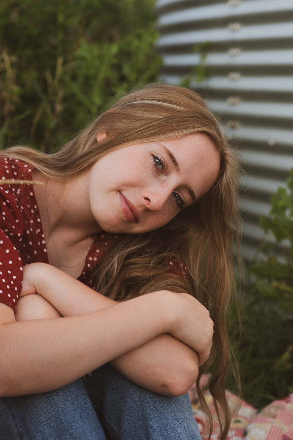 senior girl sitting with head on her arms