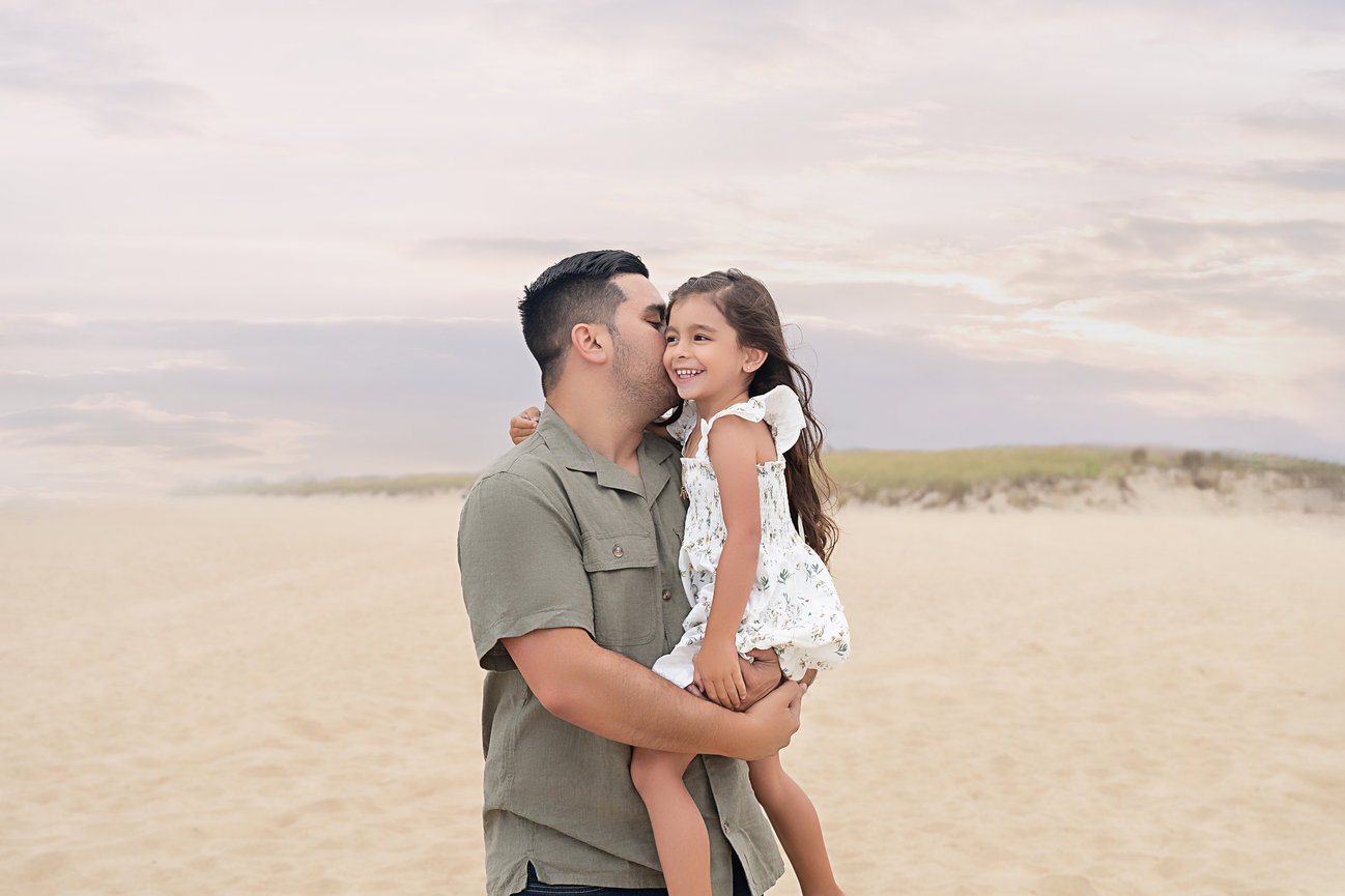 Father and daughter hugging on a quiet Monmouth County beach path