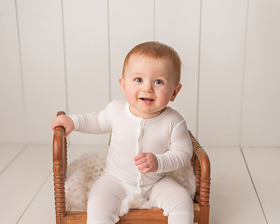 Minimalist first birthday portrait in Holmdel, NJ with baby on linen cushion and white floor