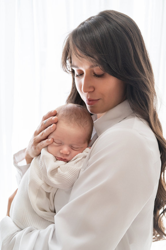 Organic connection between mother and newborn during soft, baby-led photo session in Sea Girt, NJ