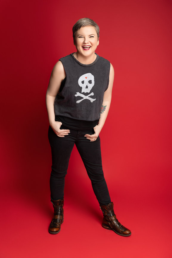 portrait session in Fort Worth studio with red backdrop and skull graphic shirt.