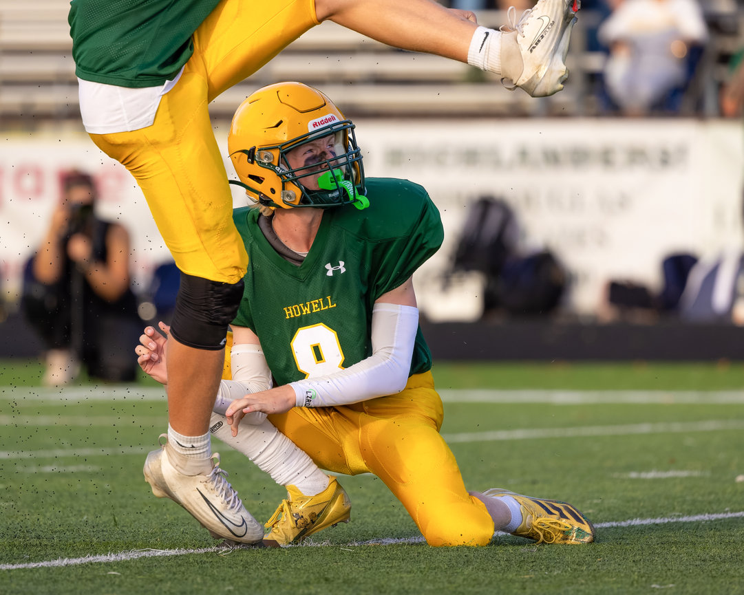 Football player being tackled during a night game.