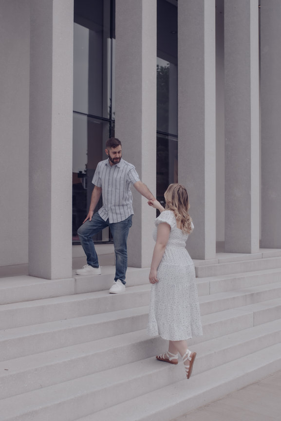 Couple standing on steps holding hands