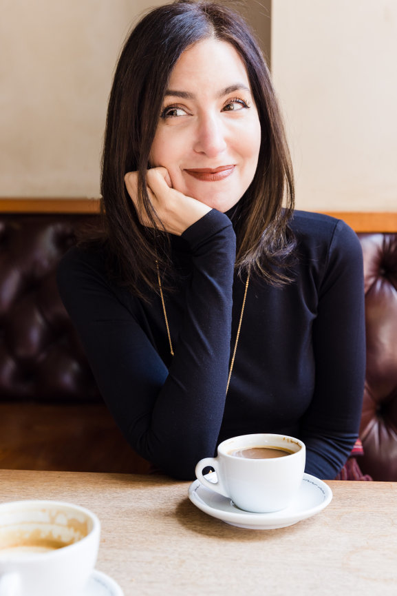 Woman sitting in San Francisco cafe with a cup of coffee on a table
