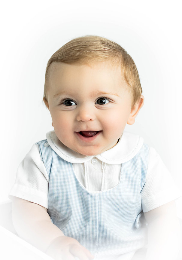 Soft vignetted portrait of baby in heirloom wardrobe