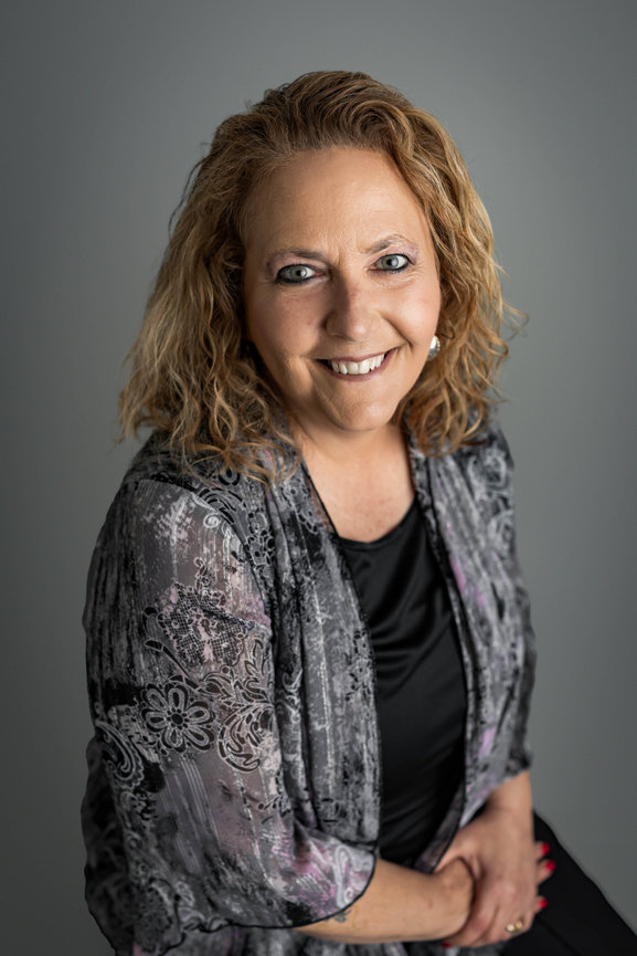Smiling professional woman posing for studio headshot