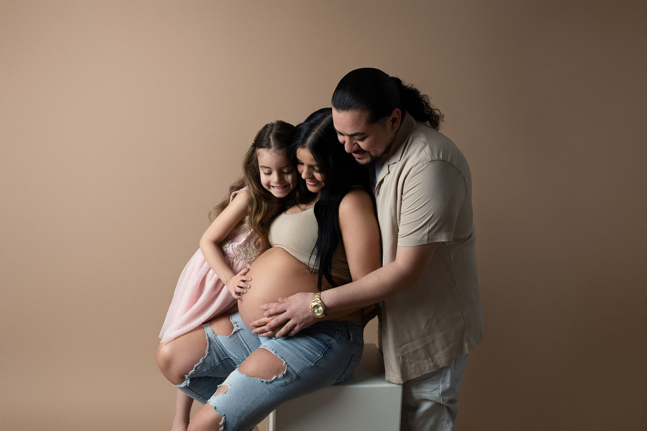 mother, daughter and father taking maternity photos together