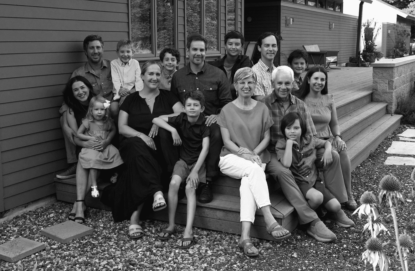 A portrait of an extended family sitting on the front porch of their home in Cedar Rapids, Iowa.