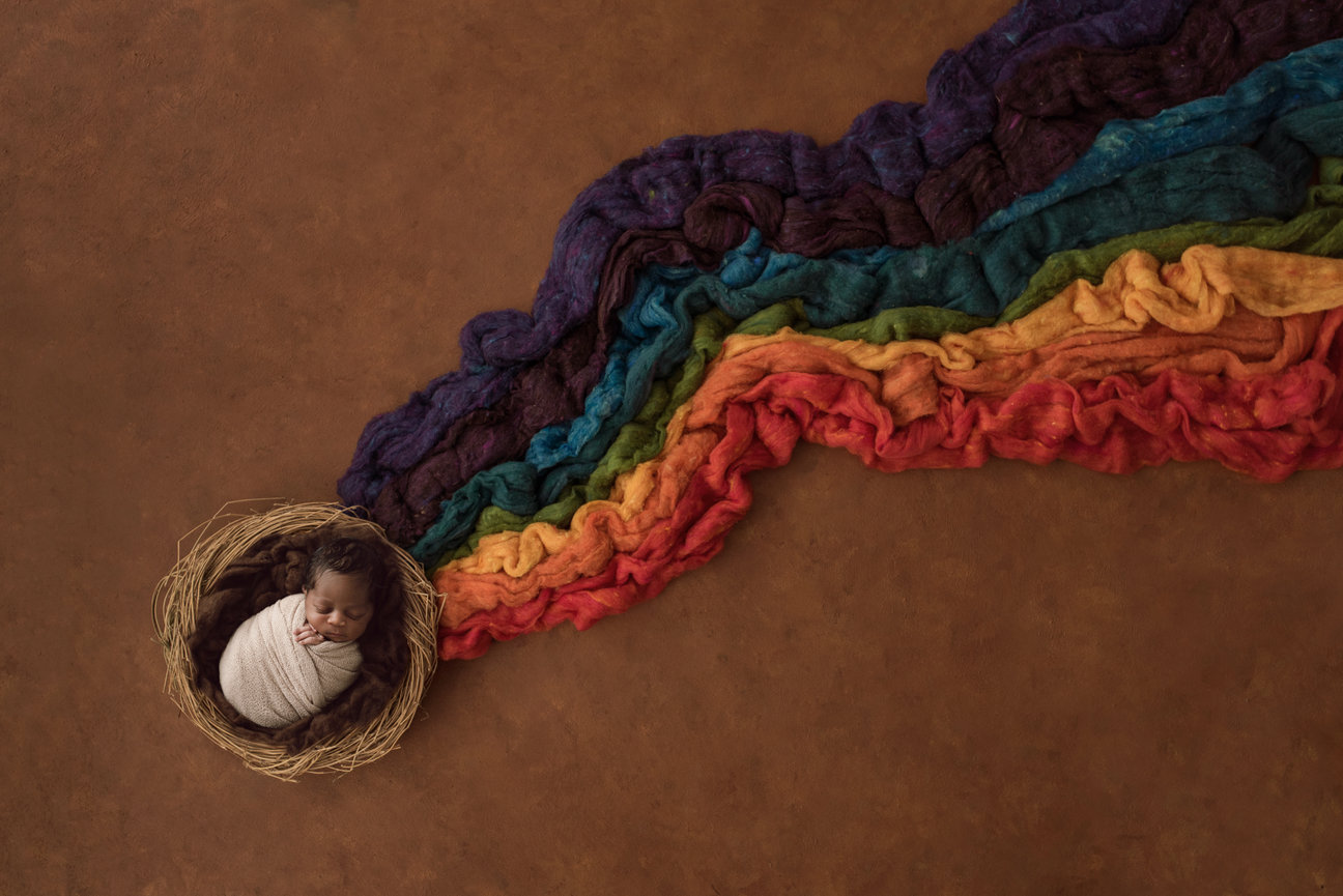 newborn photography of a rainbow baby in a basket Wake Forest NC